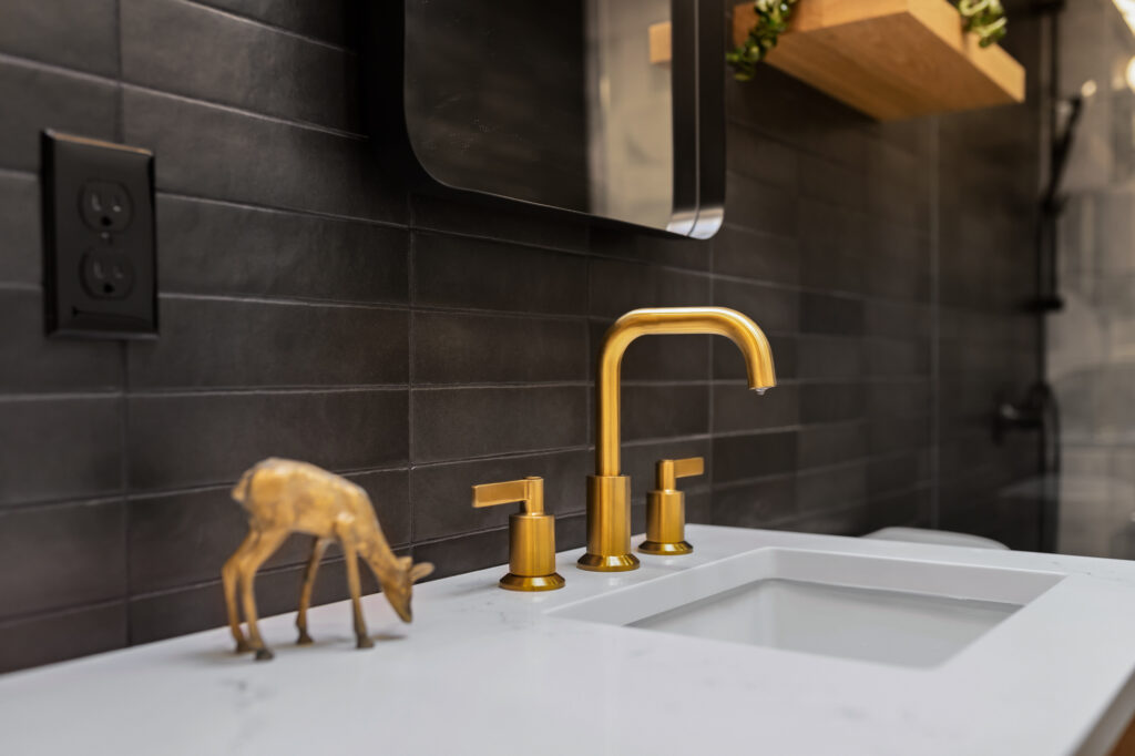gold faucets with black backspash wall tile